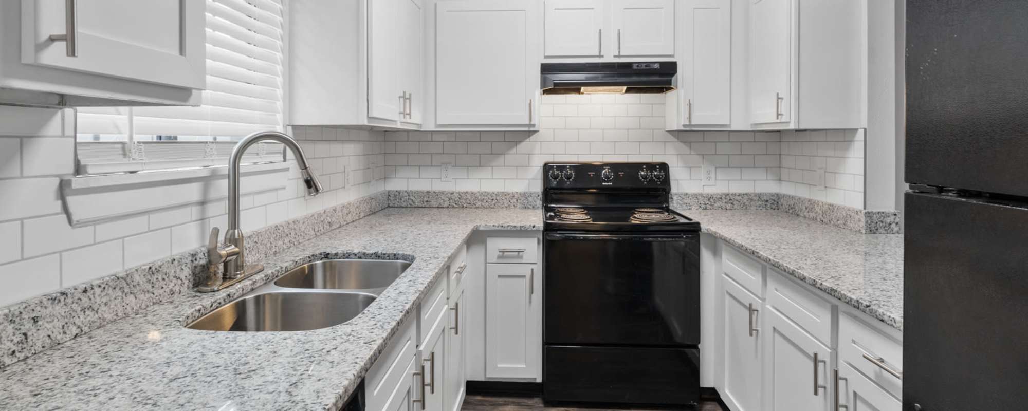 Kitchen with black oven and refrigerator at Eagle's Edge in Indianapolis 