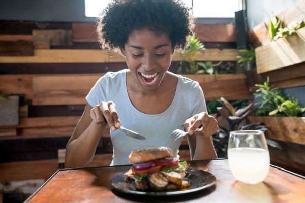 Woman enjoying a big tasty burger near Luna at Fountain Hills in Fountain Hills, Arizona