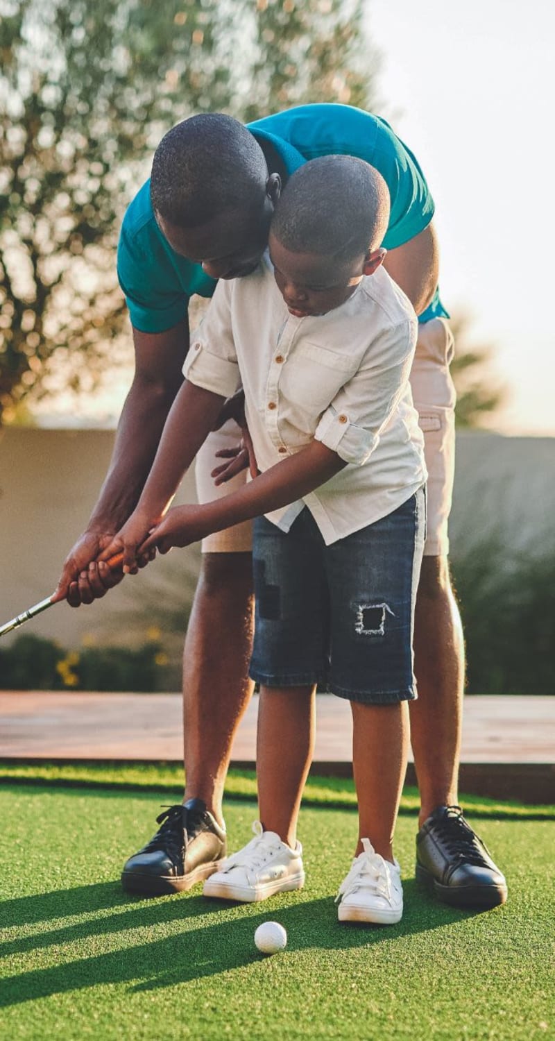 Resident teaching their kid how to golf near Artisan Carolina Forest in Myrtle Beach, South Carolina