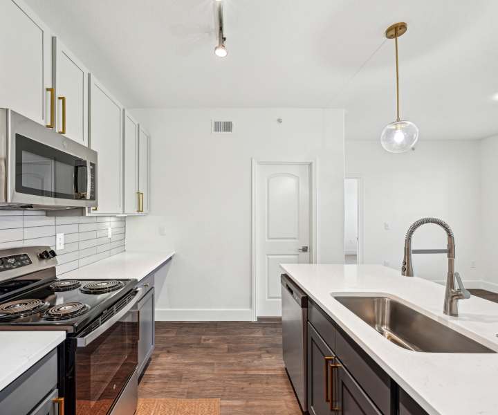 Spacious island kitchen with wood-style flooring atBarron Park in Pearland, Texas