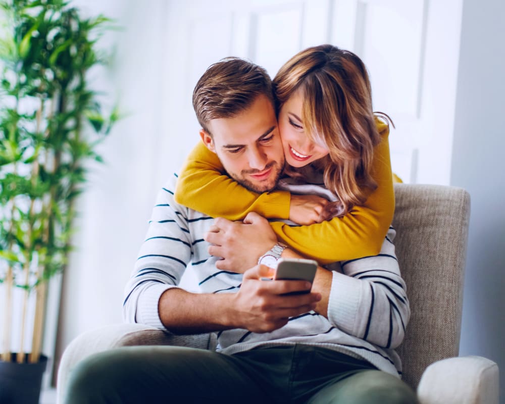 Resident couple reviewing our green policy on a mobile device in their home at Sofi Redwood Park in Redwood City, California