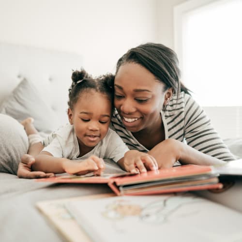 A mother reading to her daughter at The Village at Whitehurst Farm in Norfolk, Virginia