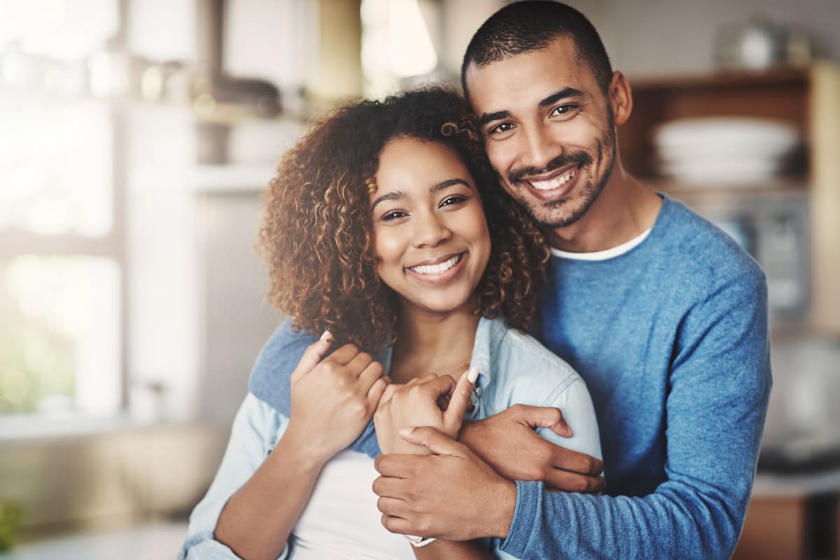 Cute couple taking a photo in the kitchen area of their home at Fields on 15th Apartment Homes in Longmont, Colorado