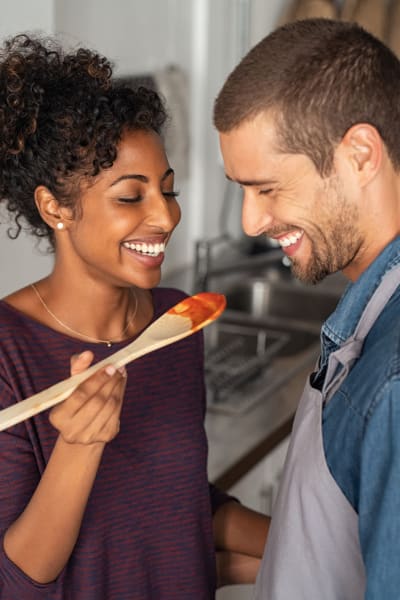 Resident laughing and cooking together at The District Flats in West Palm Beach, Florida