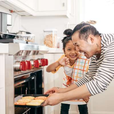 A father and his daughter cooking in a kitchen at Prospect View in Santee, California