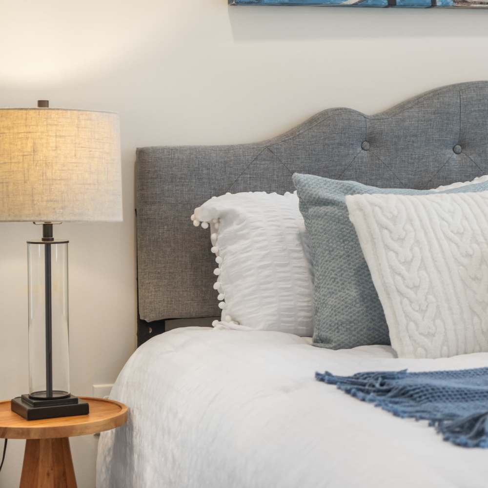 Bedroom with king size bed and side table lamp at The Simone in Silver Spring, Maryland