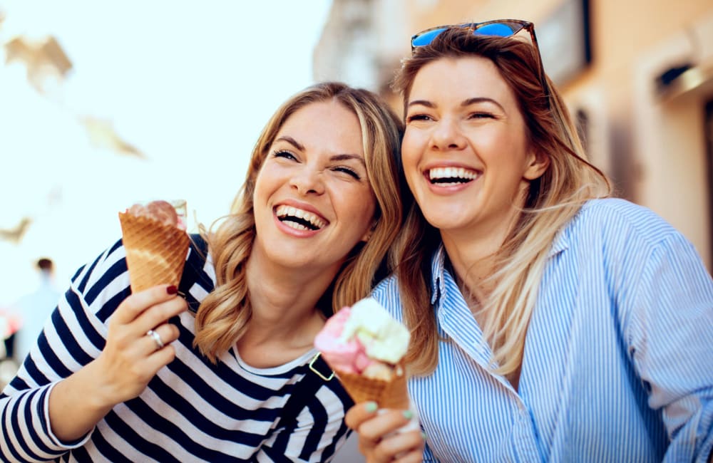 Two smiling women eating ice cream near Eagle Lake Landing in Indianapolis, Indiana