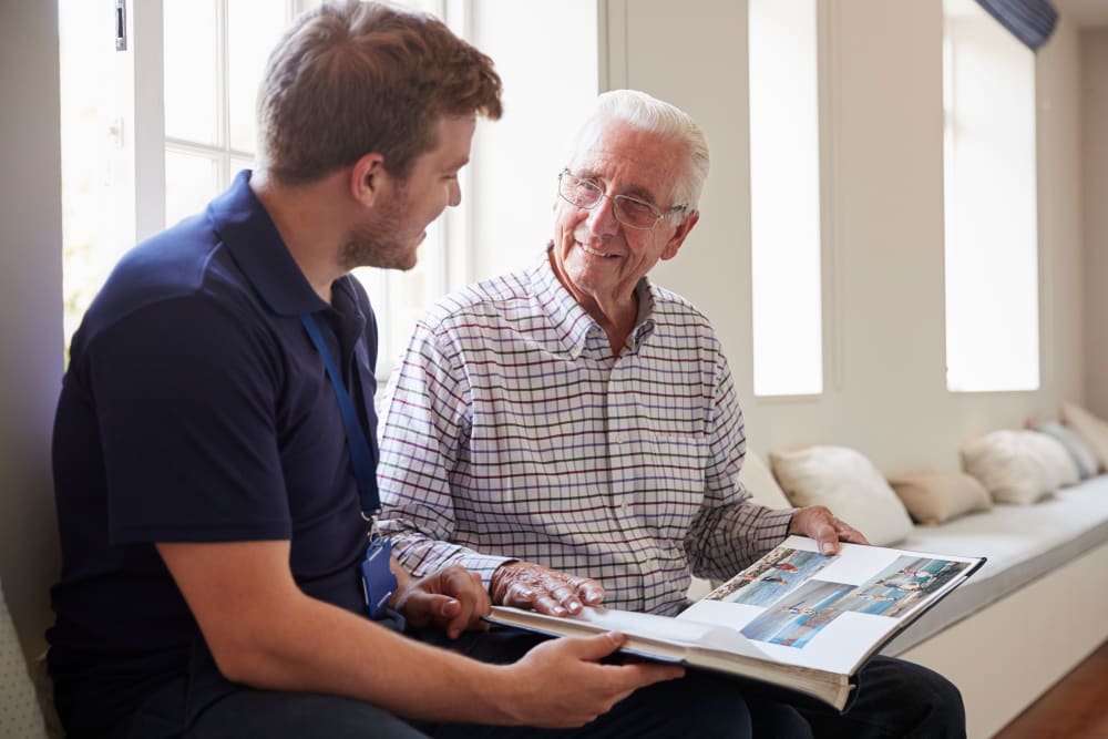 Senior gentleman and younger man reading at Regency Palms Colton in Colton, California.