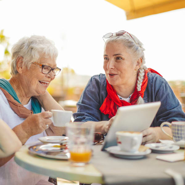 Two residents looking at a computer at The Woodmark at Daytona Beach in Daytona Beach, Florida