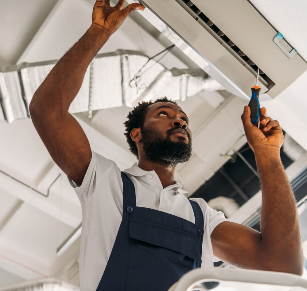 Employee fixing an air conditioner near Montecito Apartments in Santa Clara, California