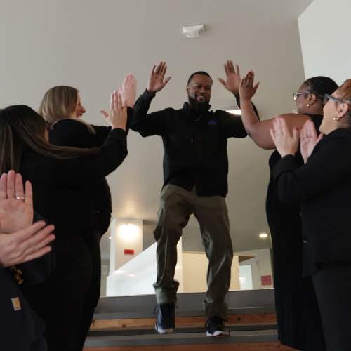 Team members cheering and giving high‑fives at Pillar Properties in Seattle, Washington