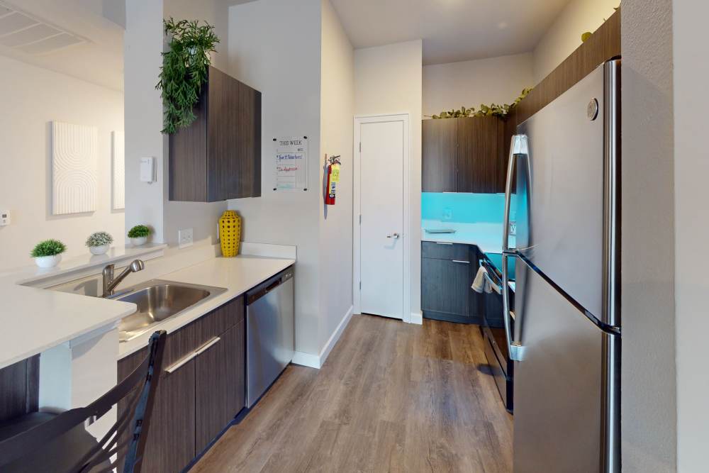 Apartment kitchen with dark wooden cabinets at The Quarters at Columbia in Columbia, Missouri