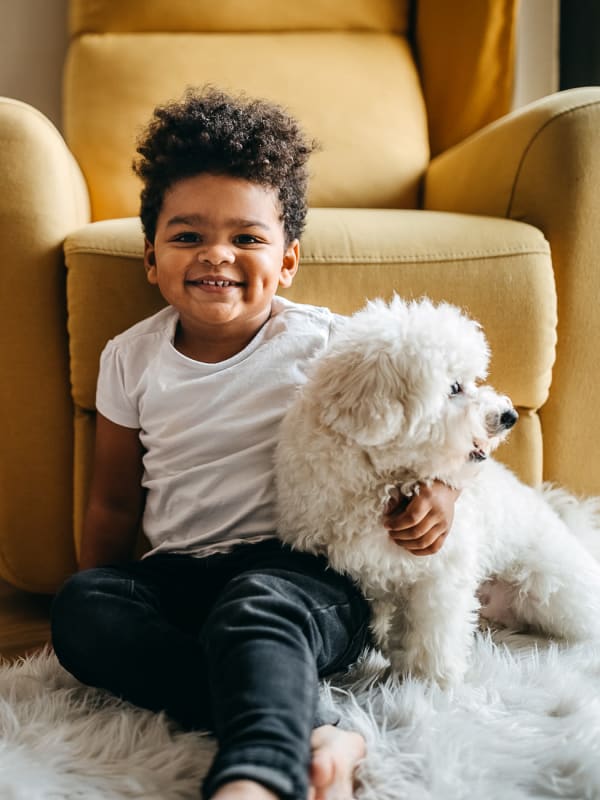 Young resident and his dog in their pet-friendly home at Tuscany Pointe at Tampa Apartment Homes in Tampa, Florida