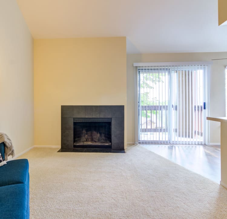 Model home's living area with plush carpeting and a fireplace at Sofi Lake Oswego in Lake Oswego, Oregon