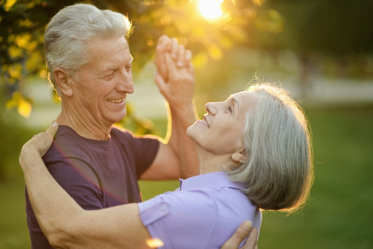 Resident couple dancing outside at Oxford Villa Active Senior Apartments in Wichita, Kansas