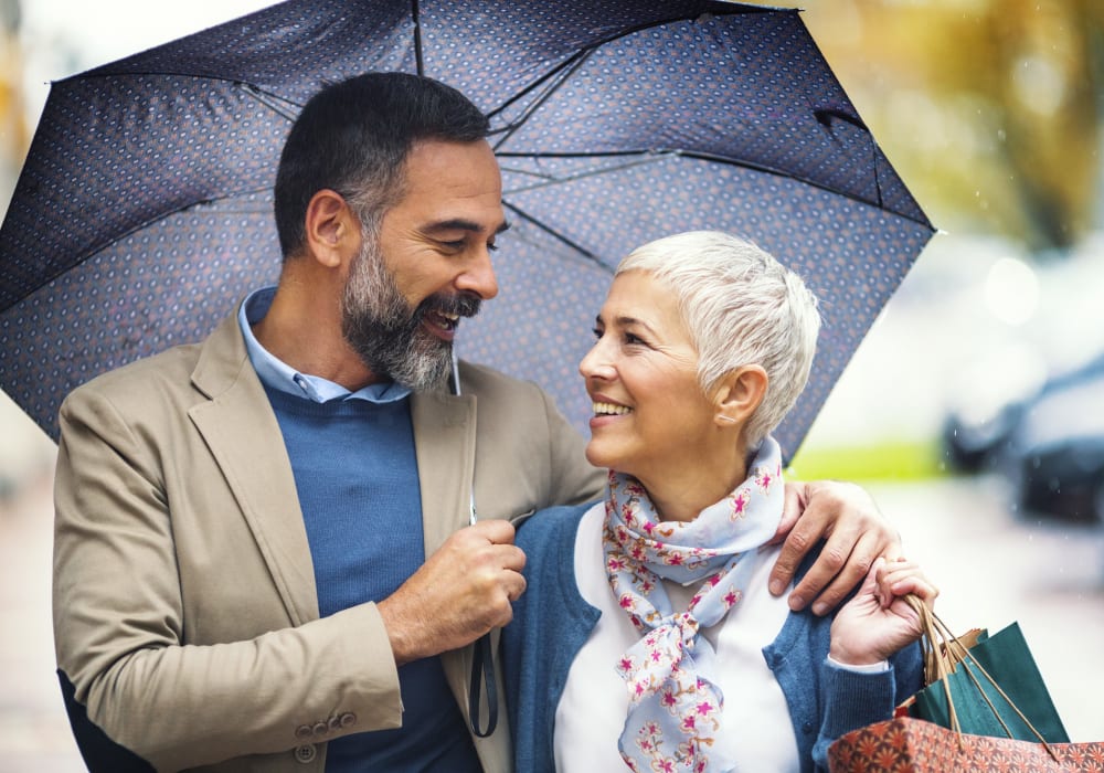 Resident couple out walking with an umbrella near The Village of River Oaks in Houston, Texas