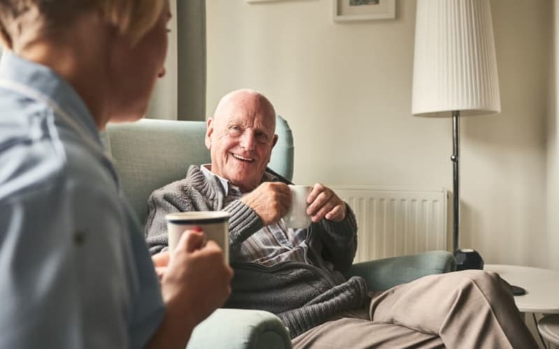 A resident having coffee with a caretaker at Grand Villa of New Port Richey in New Port Richey, Florida