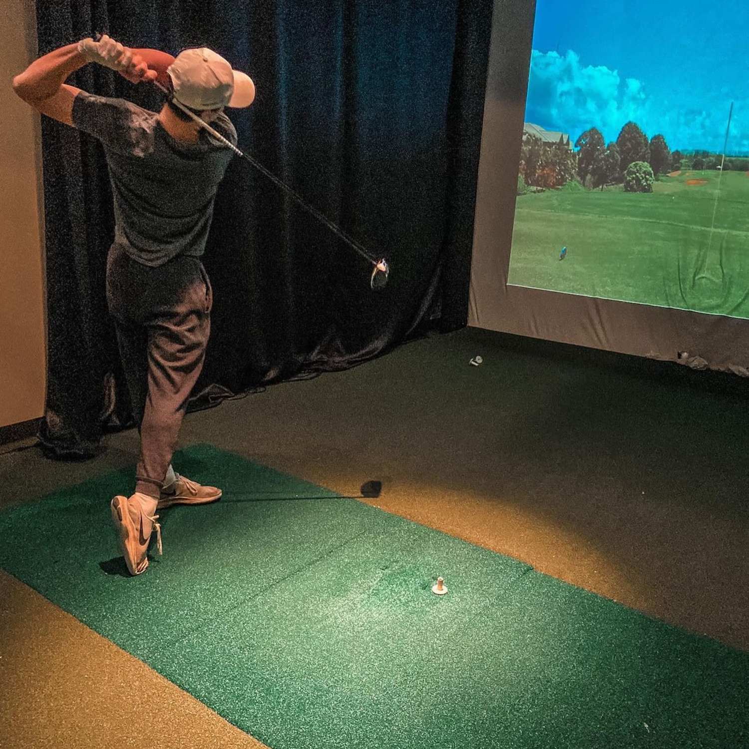 Resident using golf simulator at The Quarters at Ames in Ames, Iowa