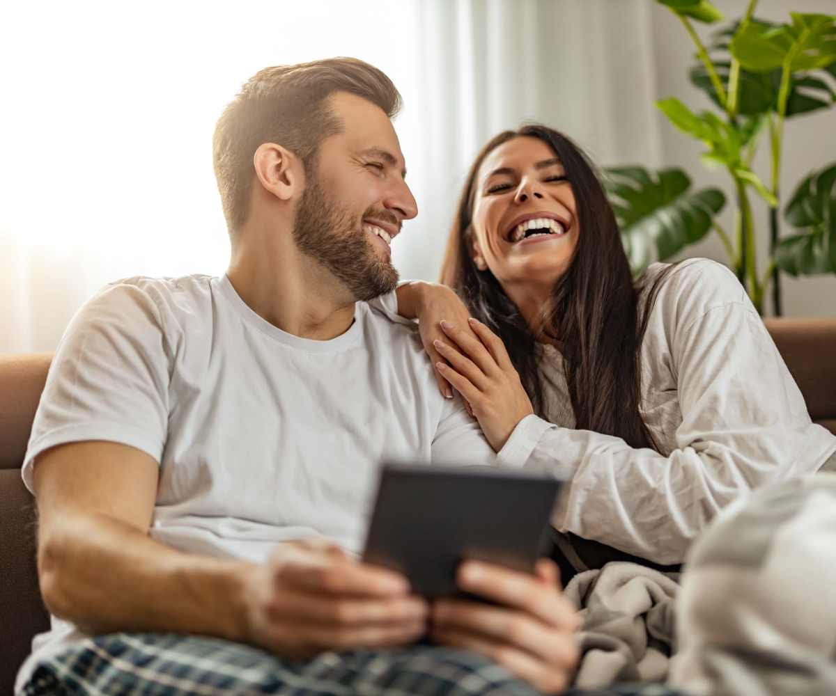 Living room with couple relaxing on couch at Lincoln Park Apartments in Duluth, Minnesota