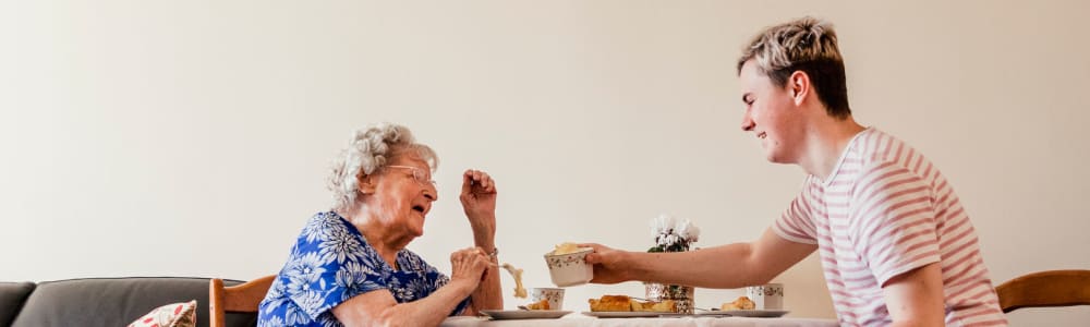 Resident having a meal with her grandson in her home