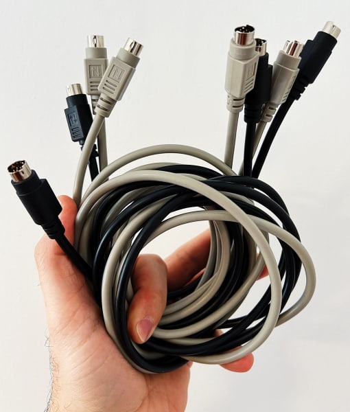 A hand holding multiple wrapped up cable wires
