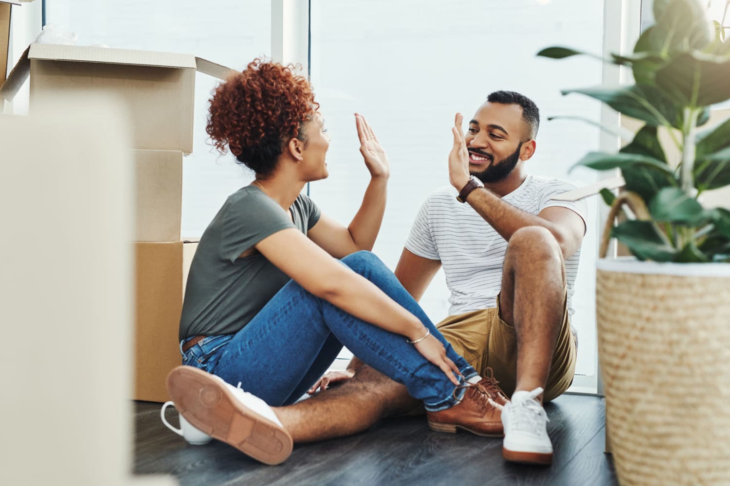 Couple just getting done unpacking and high fiving at Parkway Apartments in Williamsburg, Virginia