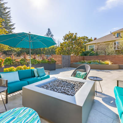 Table with an umbrella and chairs at the main outdoor common area at Mia in Palo Alto, California