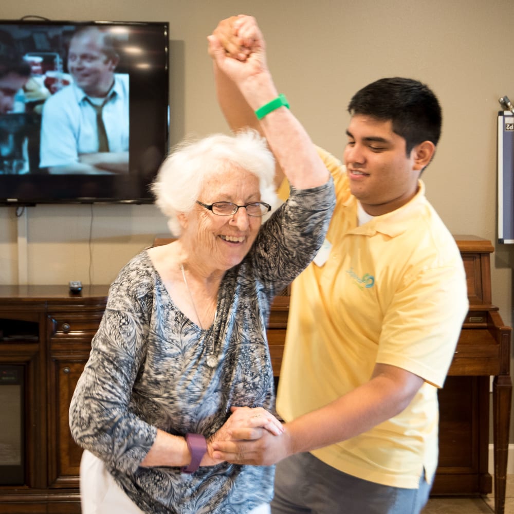 Resident and staff member dance at Inspired Living in Royal Palm Beach, Florida