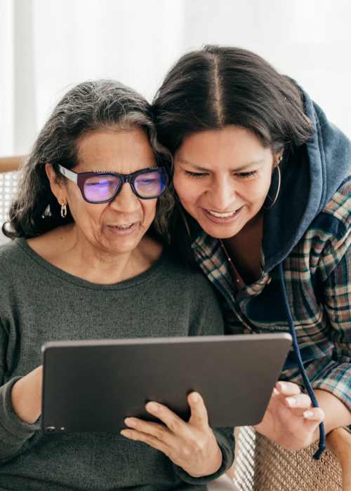 Mother and daughter learning about assisted living communities on a tablet near Grand Villa of Ocala in Ocala, Florida