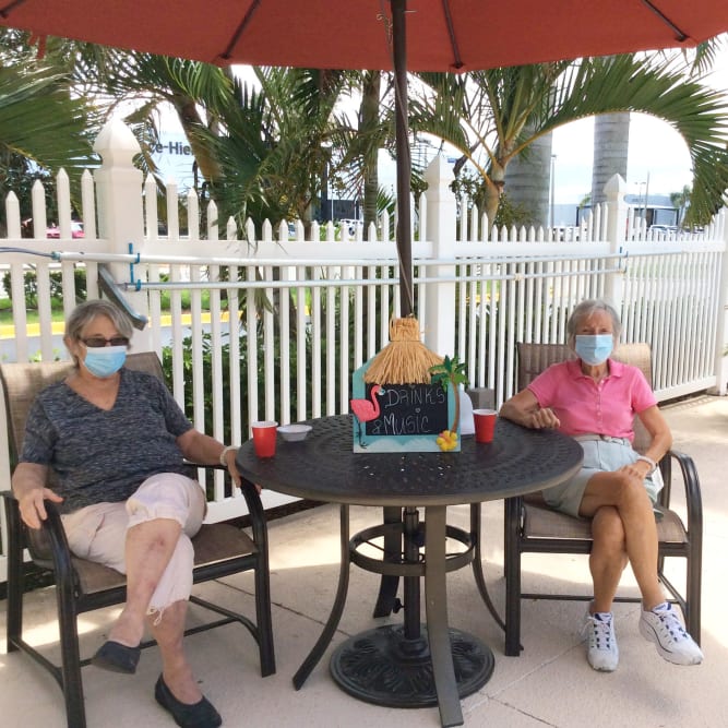 Residents sitting outside on patio at Grand Villa of Palm Coast in Palm Coast, Florida