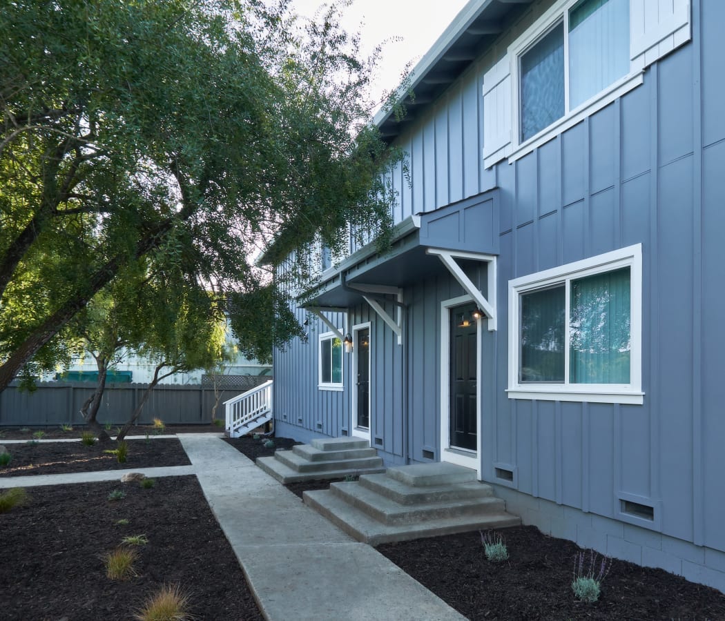 Blue exterior with a manicured walkway at 30th Ave Townhomes in Santa Cruz, California