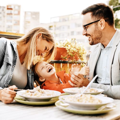 Family enjoying a meal on the patio of an Italian restaurant in Seattle, Washington near MOD Apartments