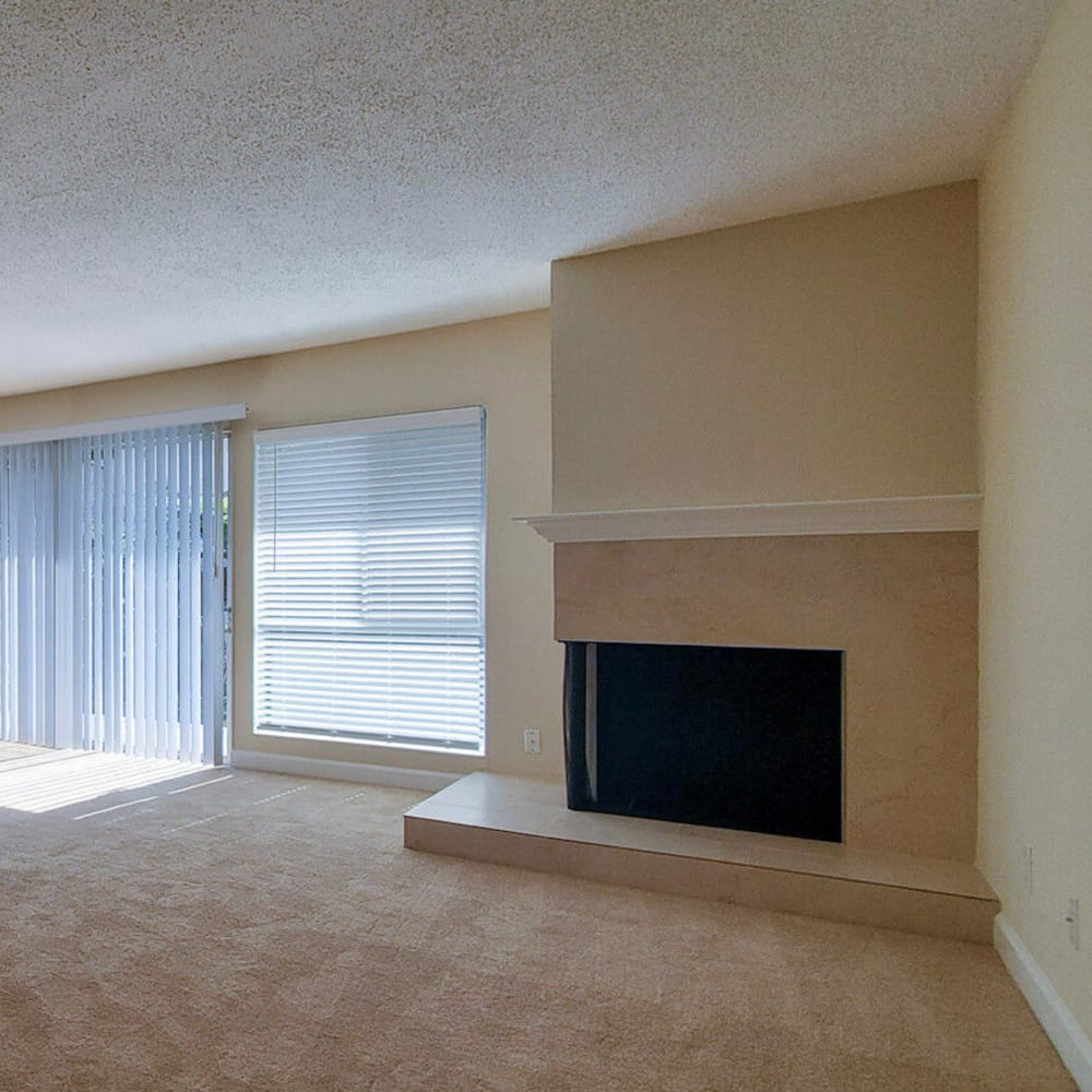 Fireplace in the living area next to sliding doors leading to the private balcony outside an apartment home at Mission Rock at Novato in Novato, California