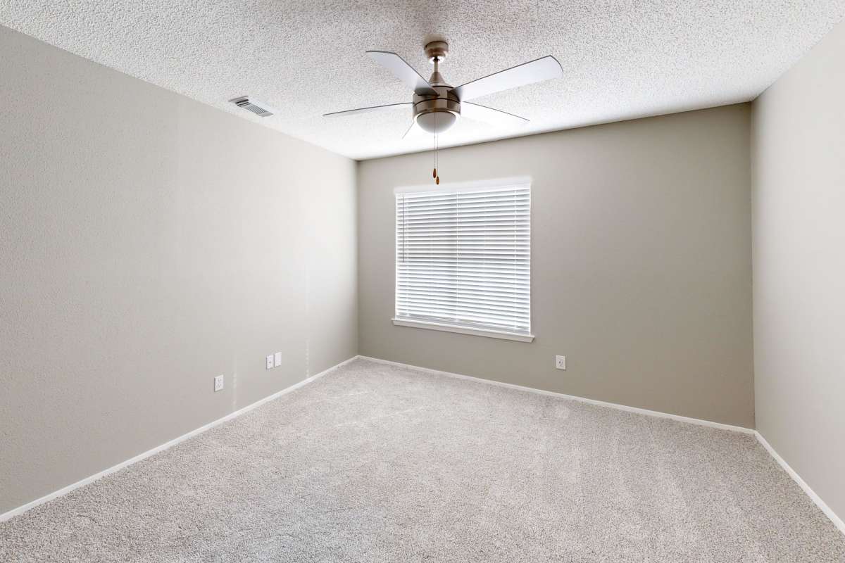 Resident bedroom with plush carpeting at Hunters Glen in Killeen, Texas