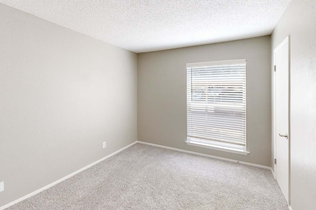 Resident bedroom with plush carpeting at Creekside in San Angelo, Texas