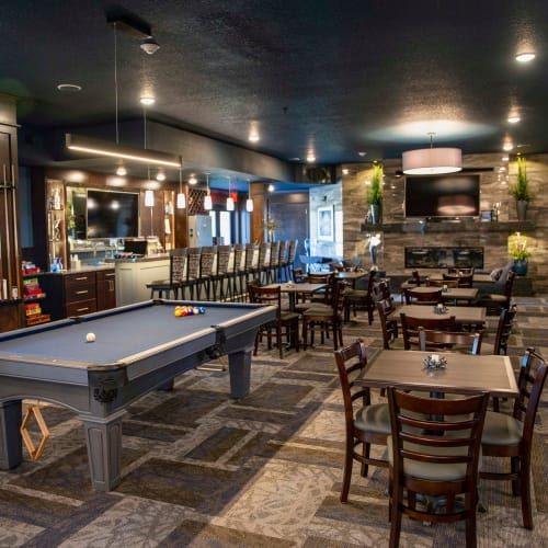 A pool table and seating in the clubhouse at Attivo Trail Waukee in Waukee, Iowa