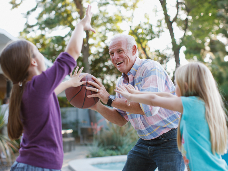 Resident playing basketball with kids at Leisure Living Lakeside in Evansville, Indiana