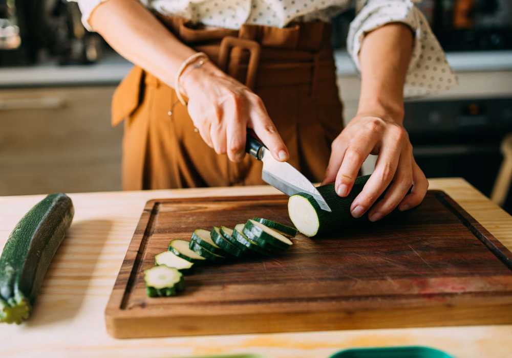 Women Slicing Fresh Zucchini on a Wooden Cutting Board at Silo Creek Apartments in Lafayette, Louisiana