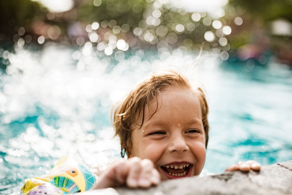 Child having a ball in the pool at Mountain View Apartments in Concord, California