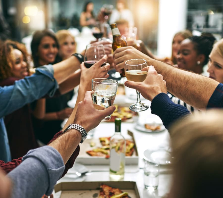 Group of resident friends out for a meal at their favorite restaurant and raising a toast to the good life at Verse Seattle in Seattle, Washington