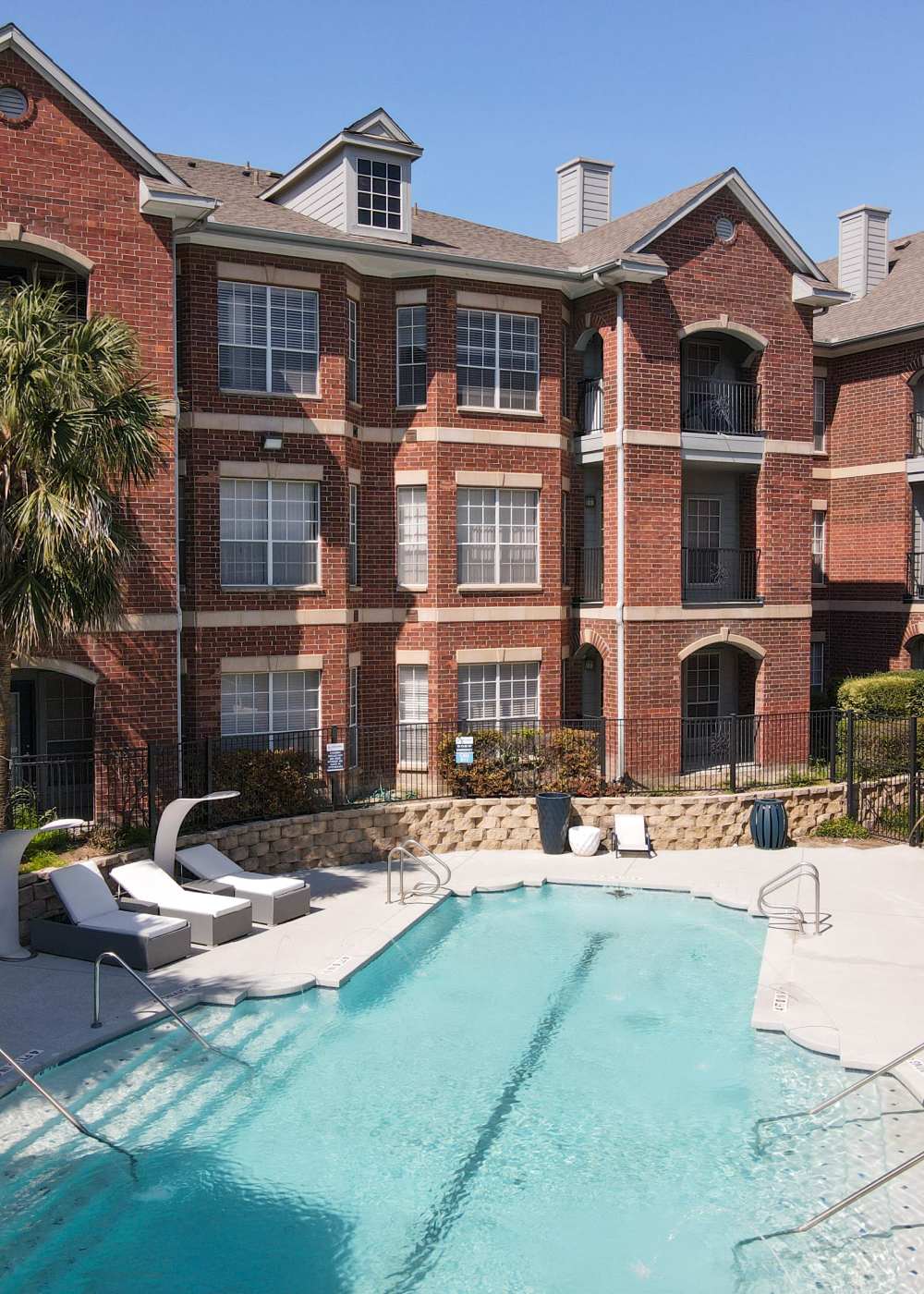 Swimming pool with lounge beds abd view to community building at Brixton in Round Rock, Texas