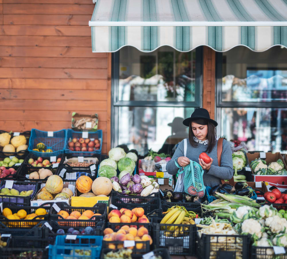 A woman looking through produce at an outdoor market near Hunt Club in Gaithersburg, Maryland