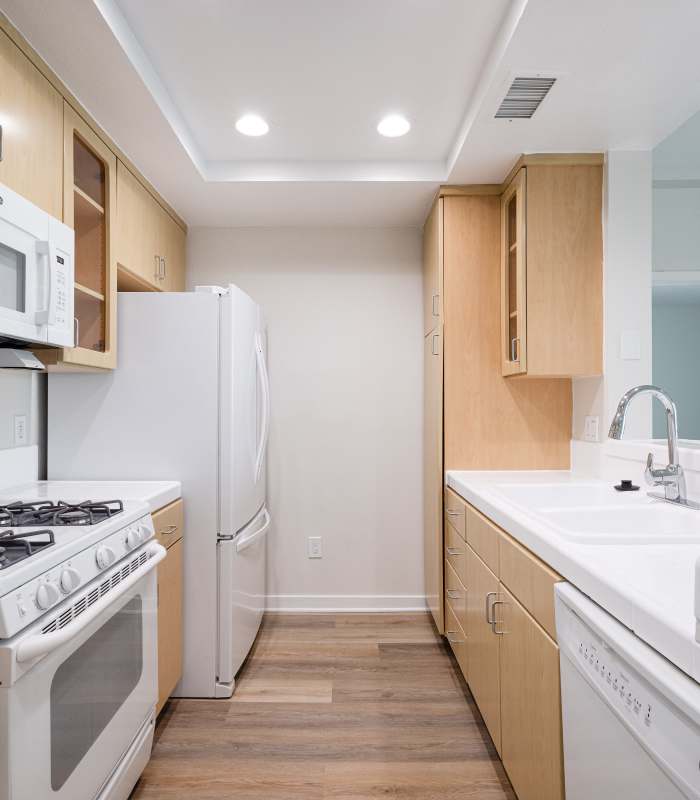 Modern kitchen with white appliances at Capri Apartments in Marina Del Rey, California.