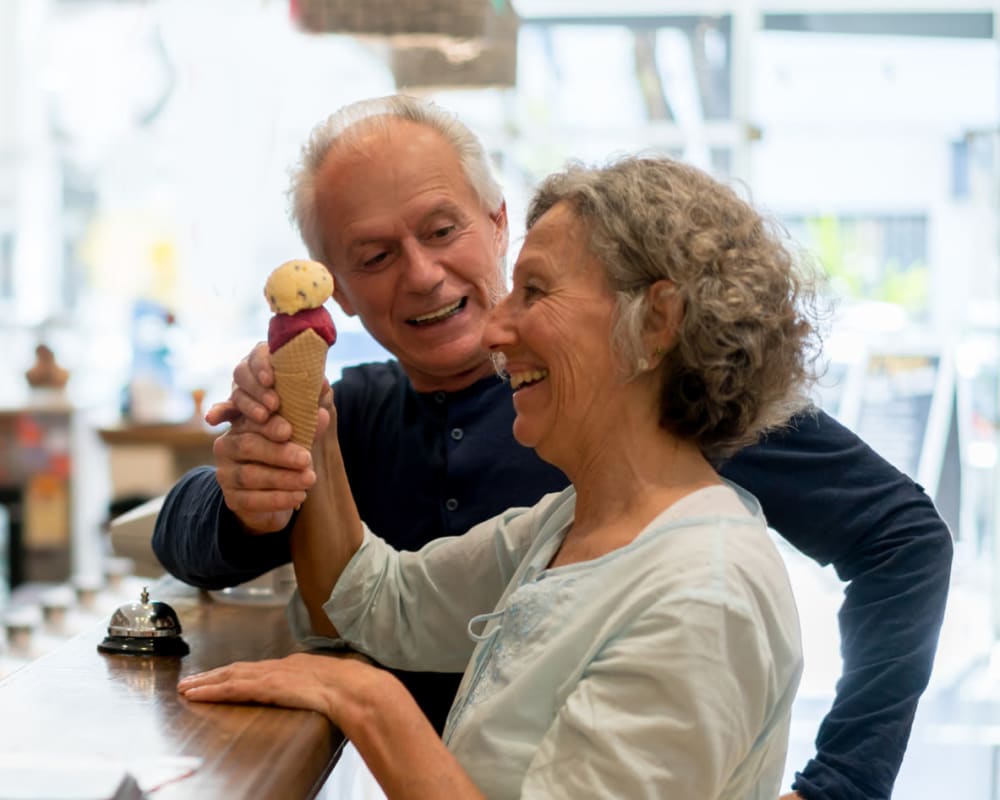 A resident handing an ice cream cone to his wife at a local ice cream shop