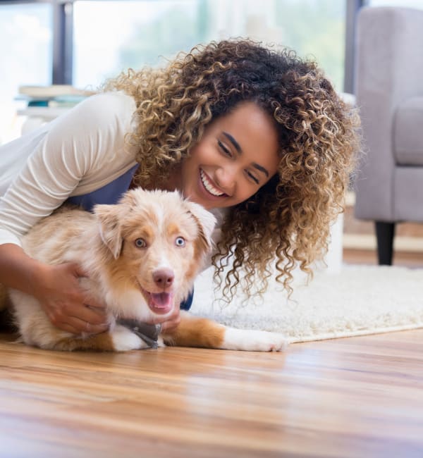 A woman with her dog on the floor of an apartment at The Alexandria in Madison, Alabama