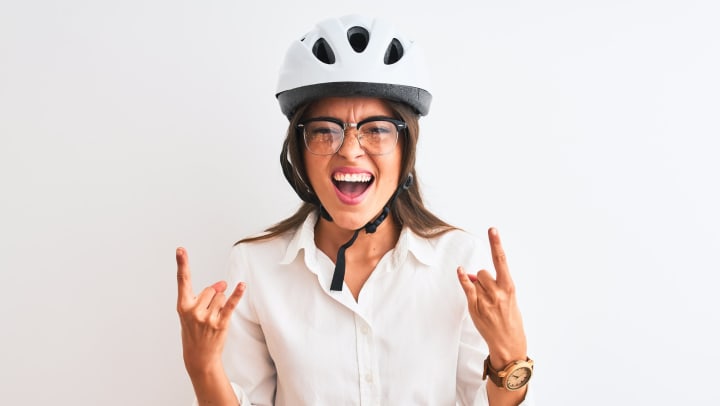  Woman wearing helmet making Devil horns with her hands. 