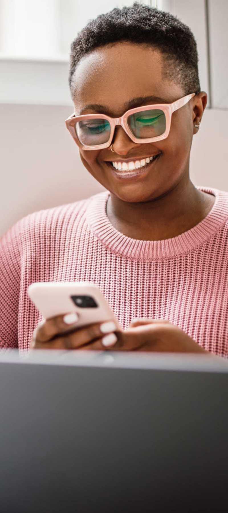 Student working on his laptop with mobile phone in hand at Mazza Grandmarc in College Park, Maryland