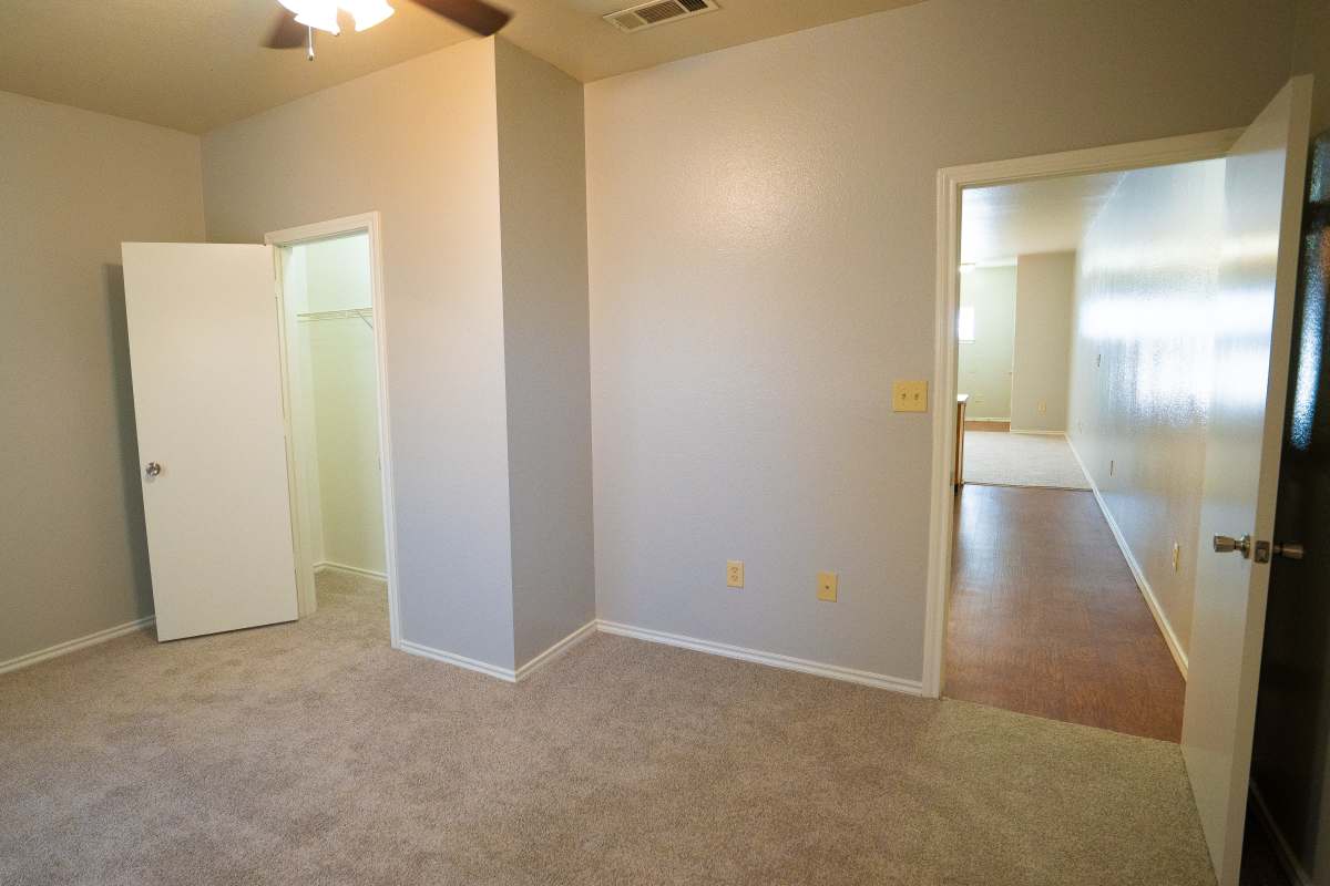 A sleek bedroom with walk-in closet at Ryan's Crossing in Marshall, Texas