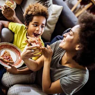 Resident family sharing pizza in their living area at 511 Queens in Charlotte, North Carolina