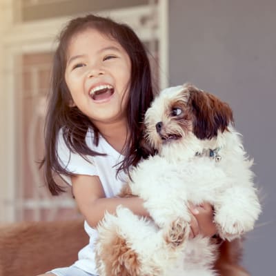 A girl holding a dog at Meriwether Landing in Joint Base Lewis McChord, Washington